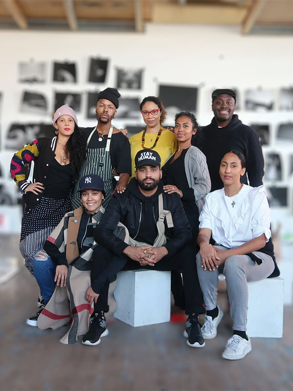 A diverse group of ARTNOIR leaders pose confidently in their studio, embodying collaboration, creativity, and cultural equity.
