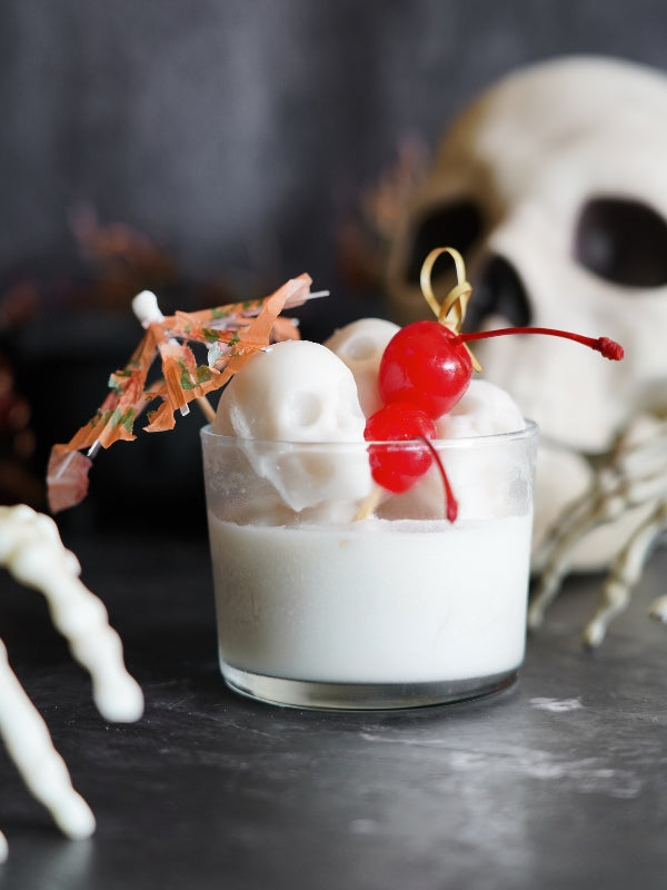 A spooky Piña Colada variation, "Piña Skullada," served in a glass with skull-shaped ice, cherries, and a festive umbrella.
