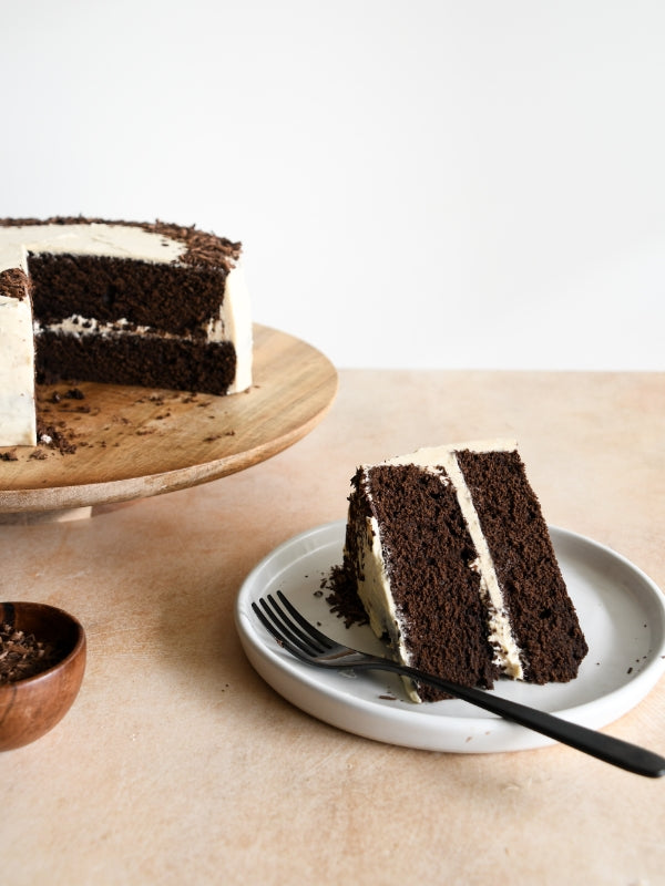 A decadent slice of chocolate cake with coffee buttercream, served with a fork. Delicious, rich, and inviting.
