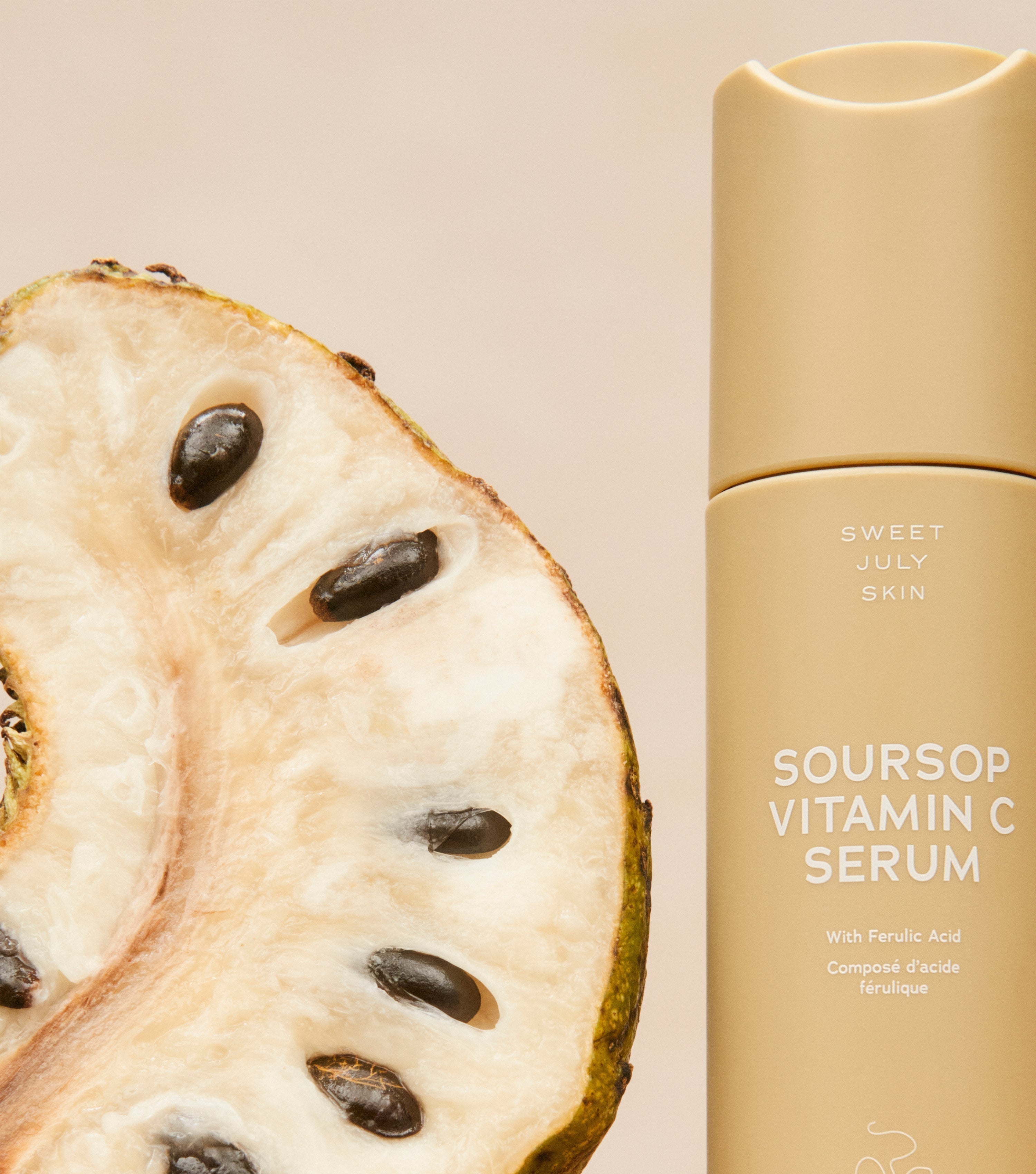 A sliced soursop fruit alongside a bottle of Sweet July Skin Vitamin C serum create a natural, organic beauty vibe.
