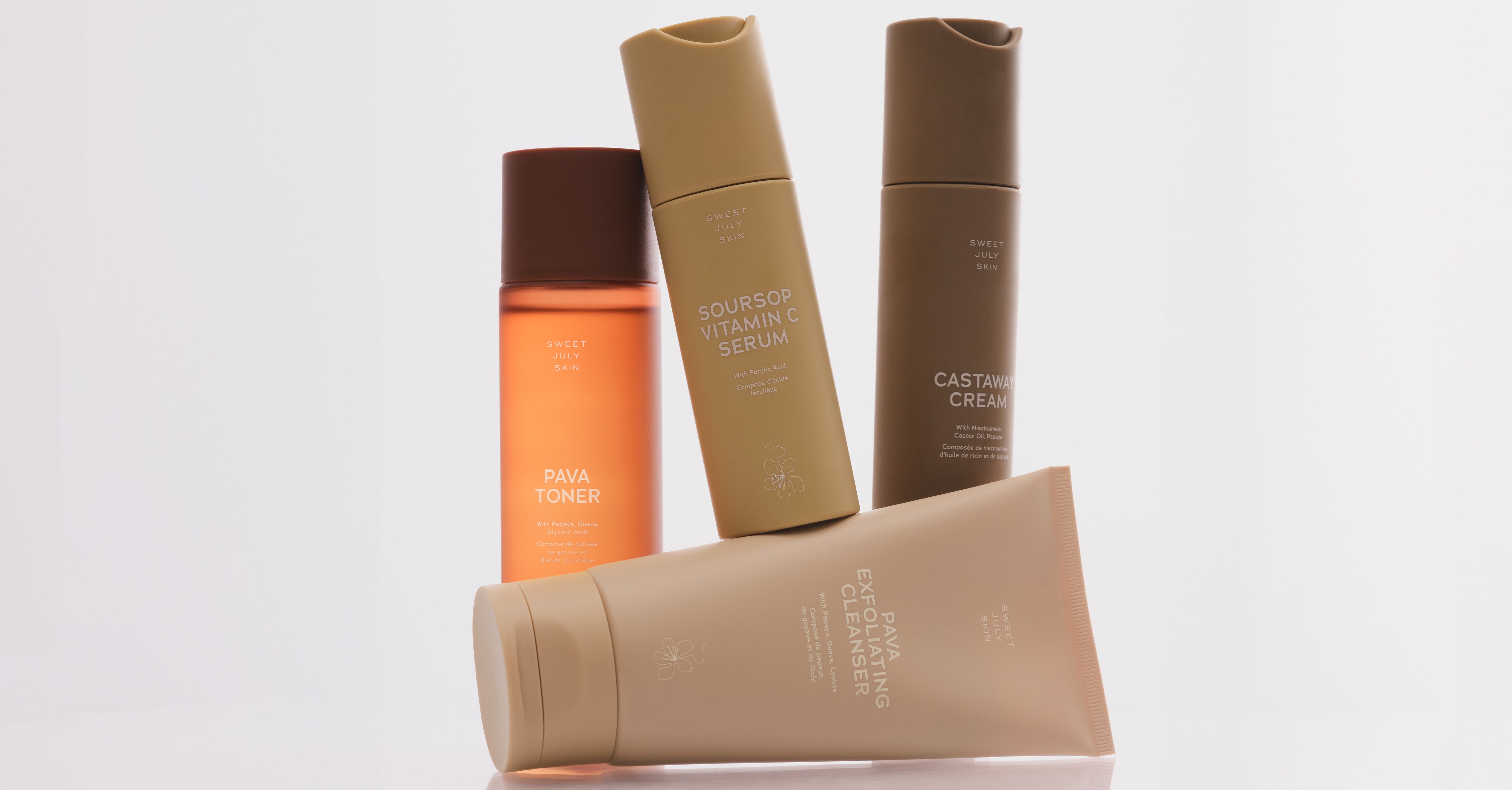Pava Toner, Soursop Vitamin C Serum and Castaway Cream standing behind a Pava Exfoliating Cleanser tube on white.