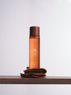 Reusable brown face rounds by Sweet July Skin sitting on a wooden shelf.