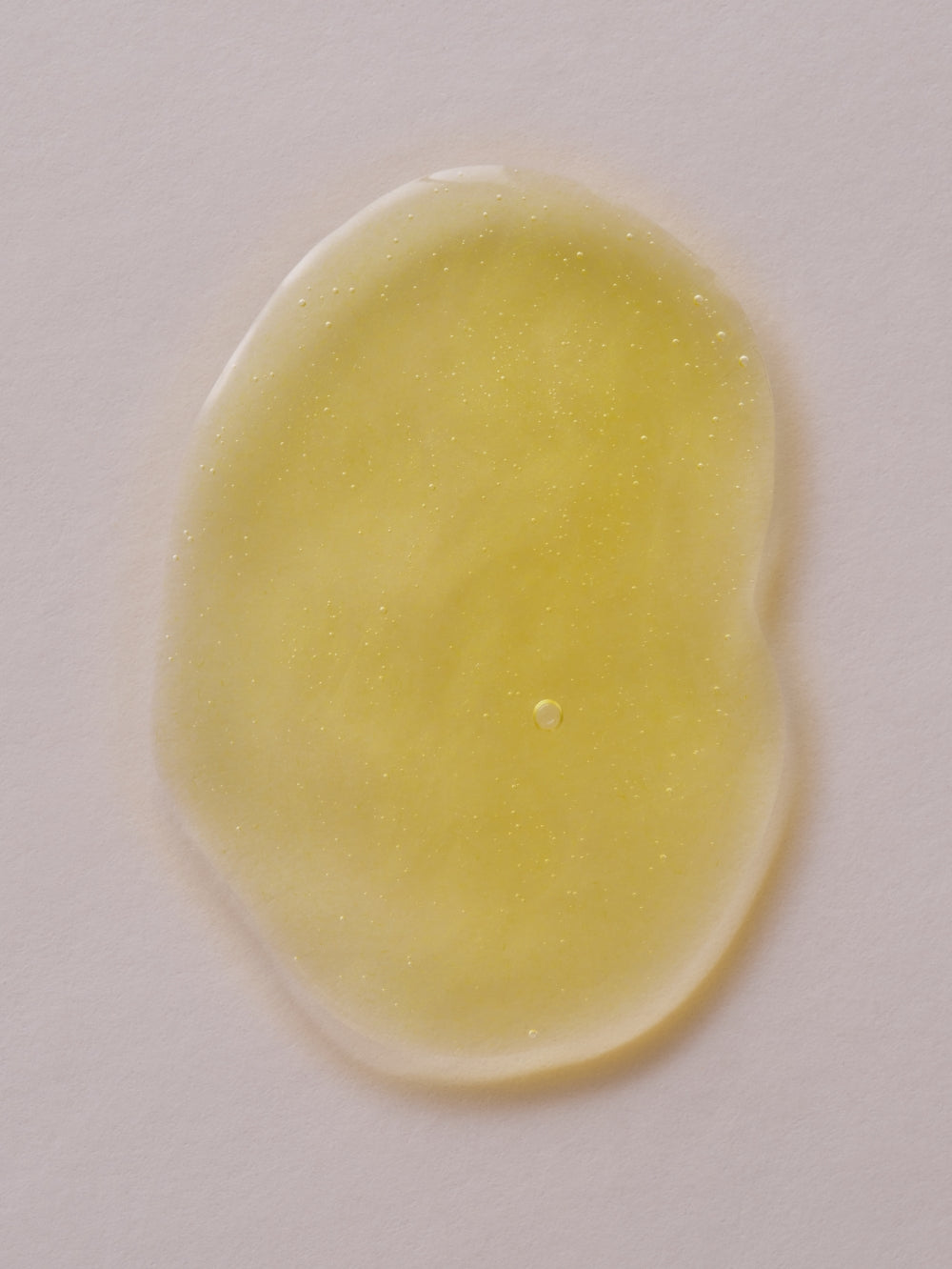 Yellow vitamin C and retinol serum by Day + Night set, with a shiny wet appearance.