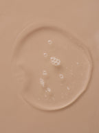 Clear serum puddle with small bubbles, revealing the tan surface underneath.