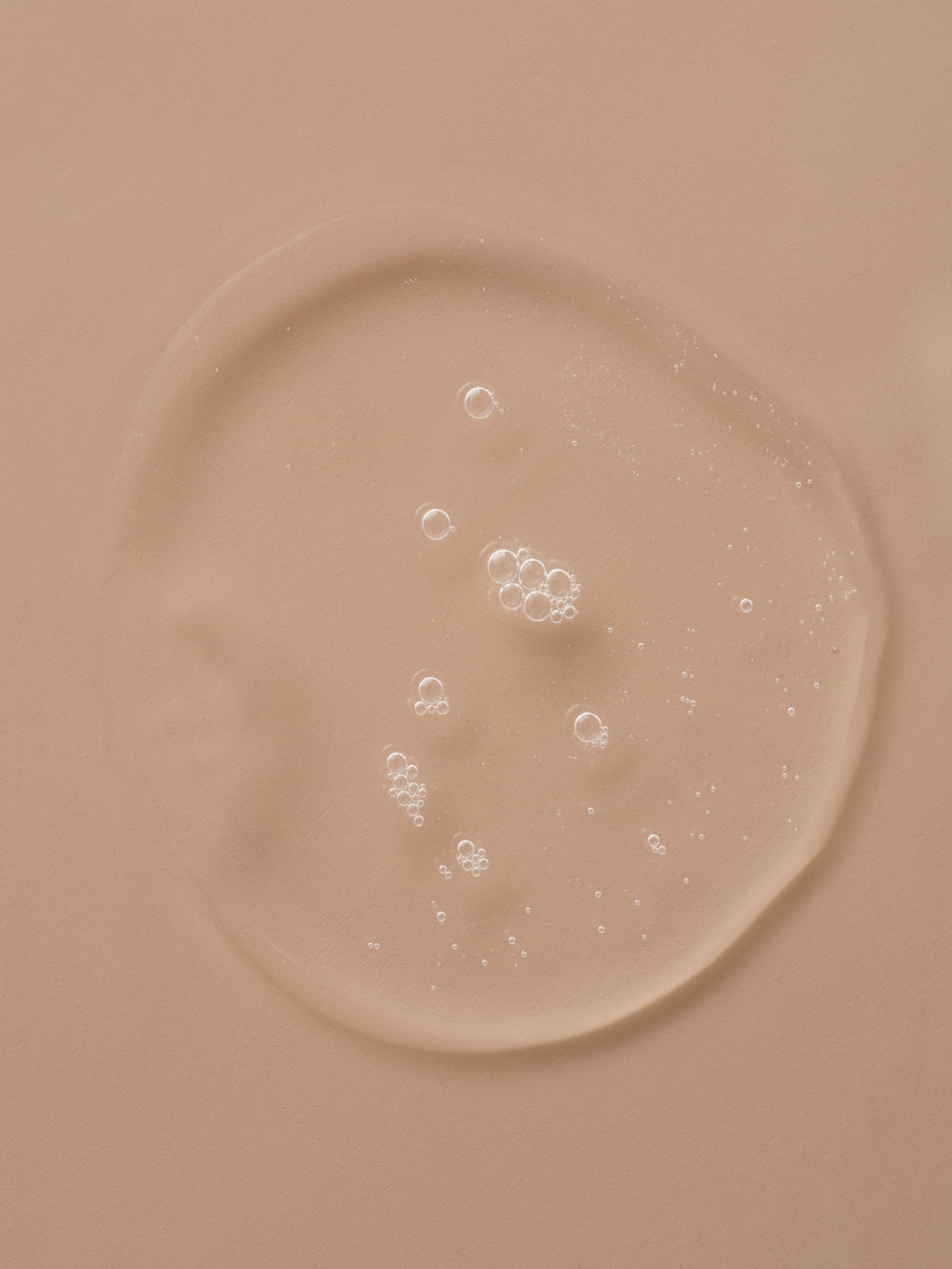 Clear serum puddle with small bubbles, revealing the tan surface underneath.