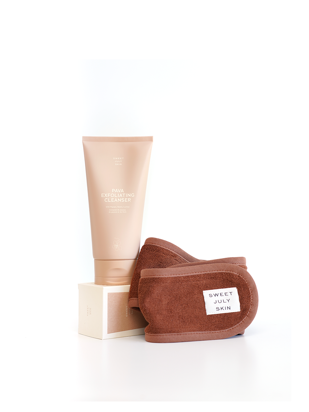 Skincare cleanser set by Sweet July Skin, including a cleanser tube and brown microfiber makeup remover pads.
