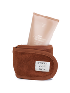 Exfoliating cleanser by Sweet July Skin in a brown terrycloth headband.