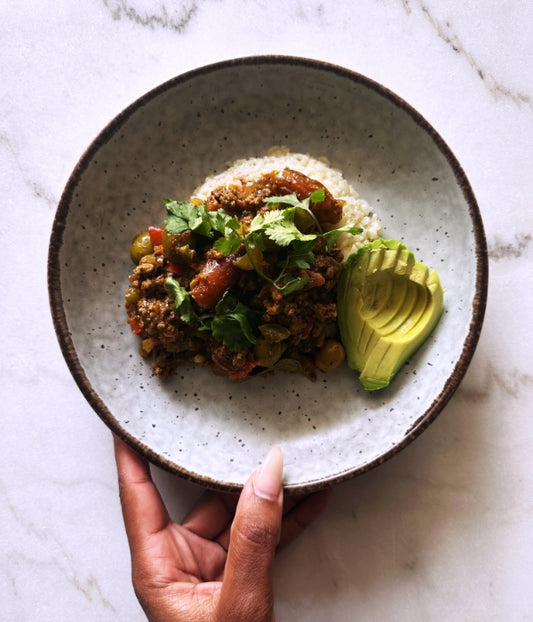 The image shows a person holding a plate of food.