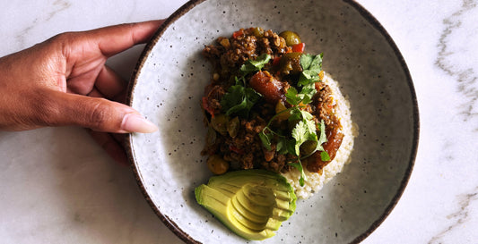 The image shows a person holding a plate of food.