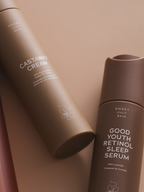 Skincare set with cream and serum by Sweet July Skin, featuring matching brown bottles and flower accents.
