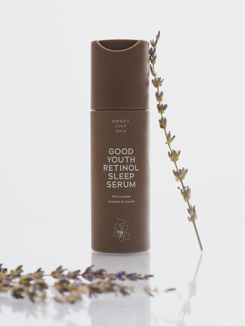 Brown retinol sleep serum by Sweet July Skin with a sprig of dried lavender next to it.