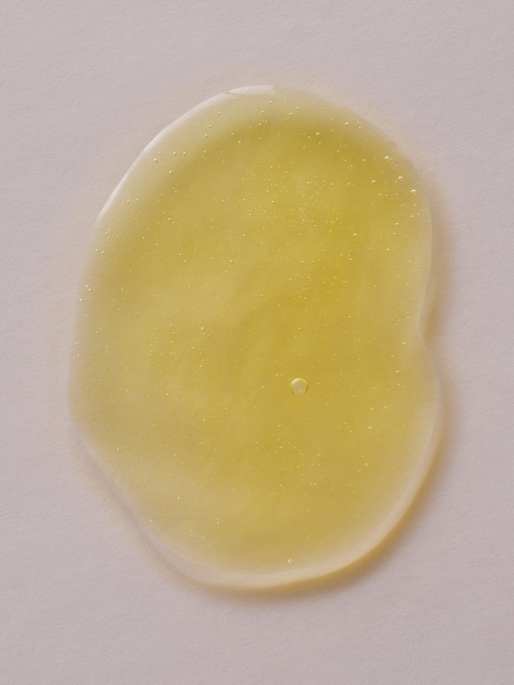 Yellow liquid essence from an unbranded set, with suspended bubbles.