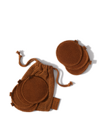 Brown reusable face rounds by Sweet July Skin inside and next to a brown drawstring bag.