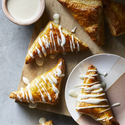 The image shows a group of waffles topped with butter and syrup on a plate. It is a photo of a delicious snack.