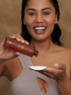 Brown skincare toner by Sweet July Skin being poured onto a white cotton pad, with a smiling woman in the background.