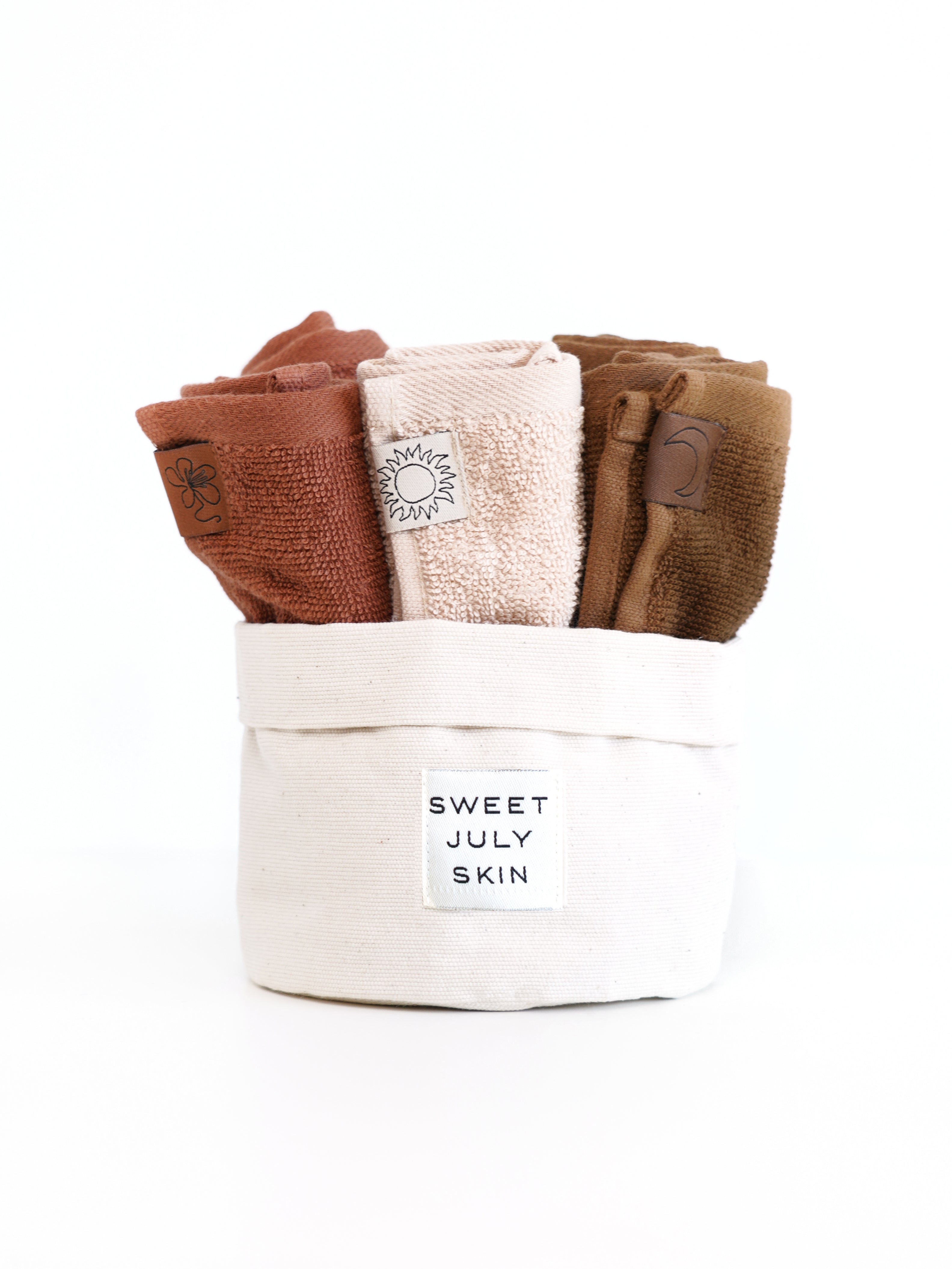 Six-piece face towel set by Sweet July Skin in a fabric basket with brand label visible.