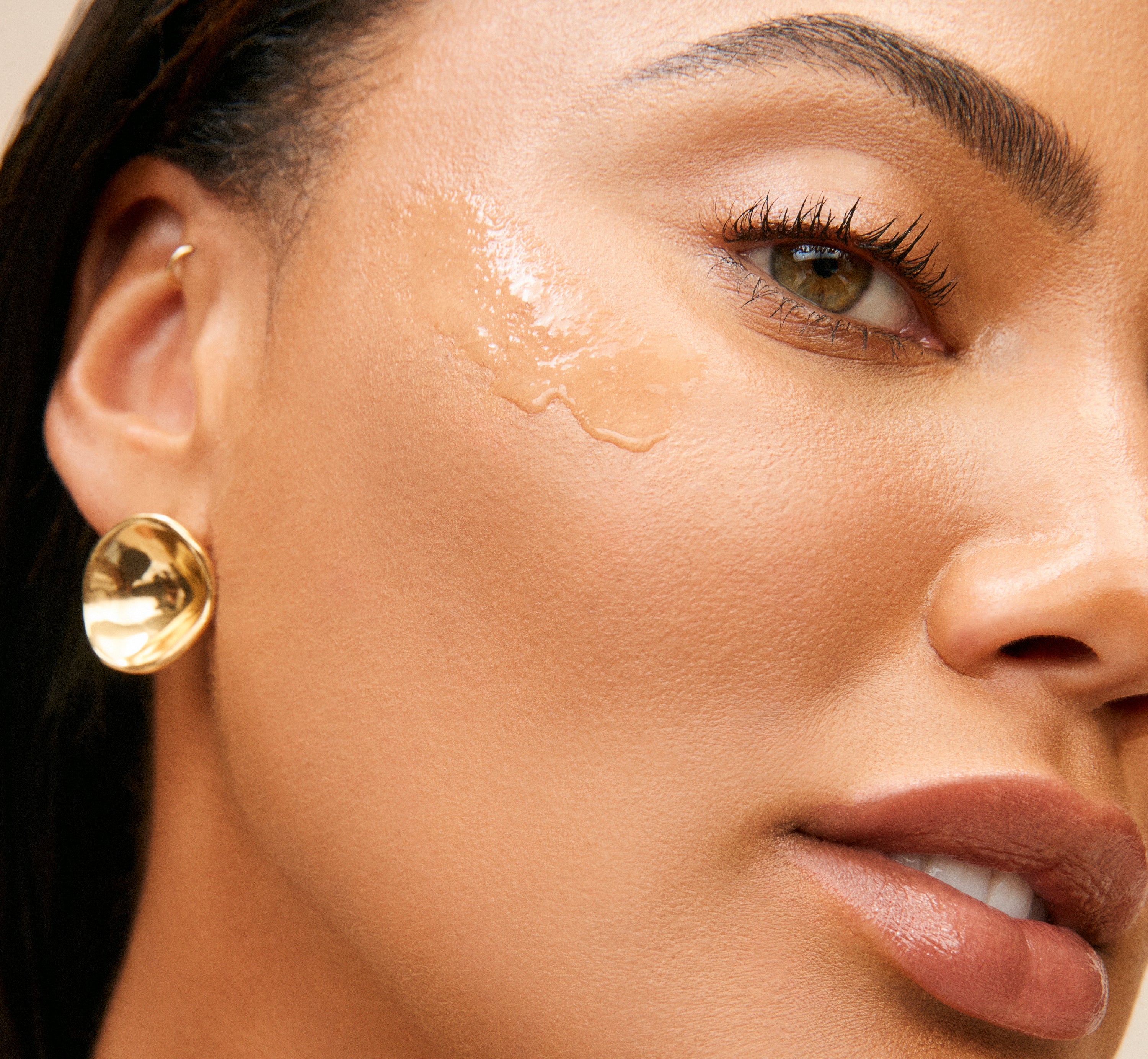 Close-up of Sweet July Skin founder Ayesha Curry wearing Soursop Vitamin C Serum with glossy hydrated skin