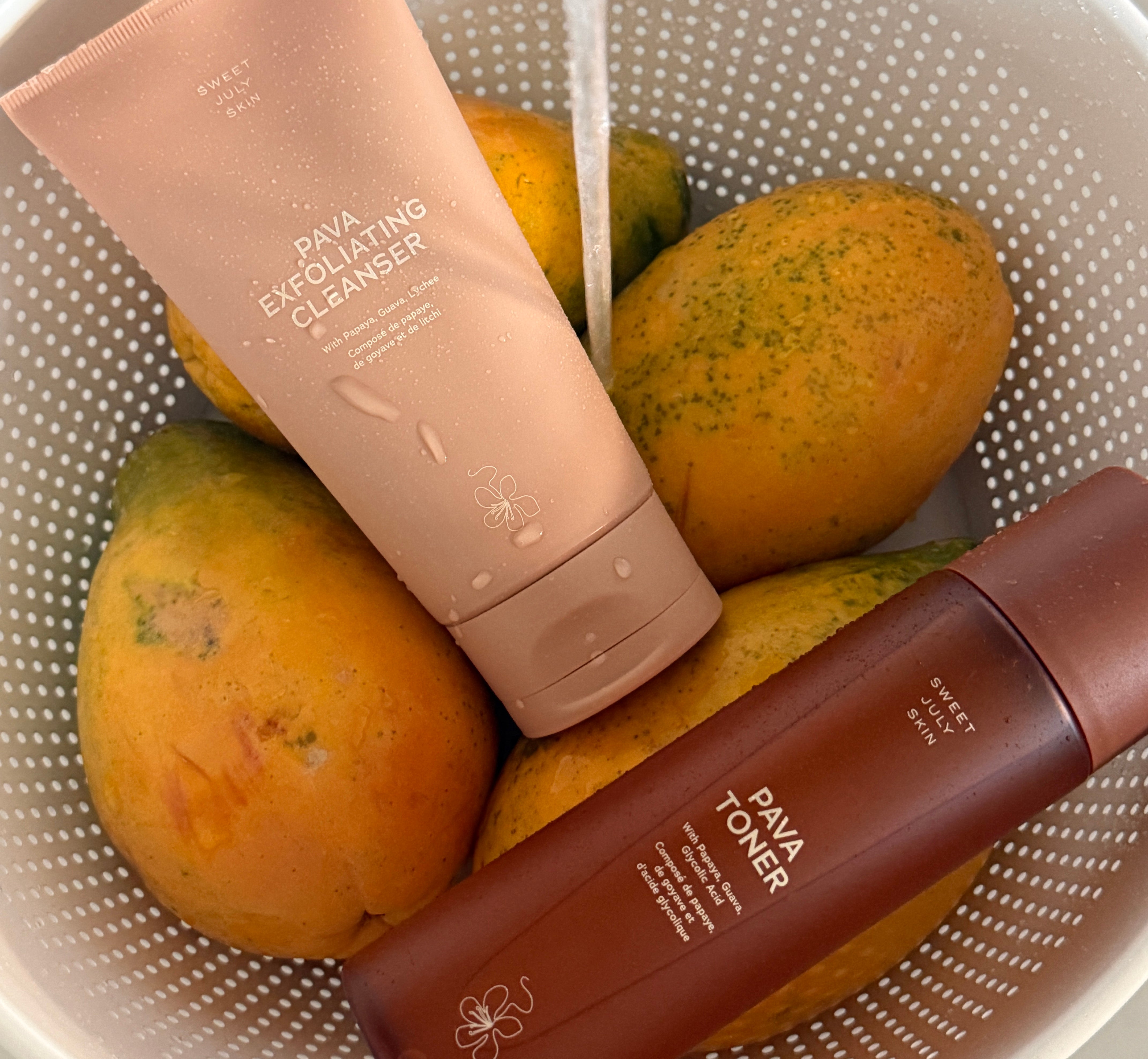 Sweet July Pava Exfoliating Cleanser and Pava Toner with fresh papayas highlighting the natural skincare ingredients